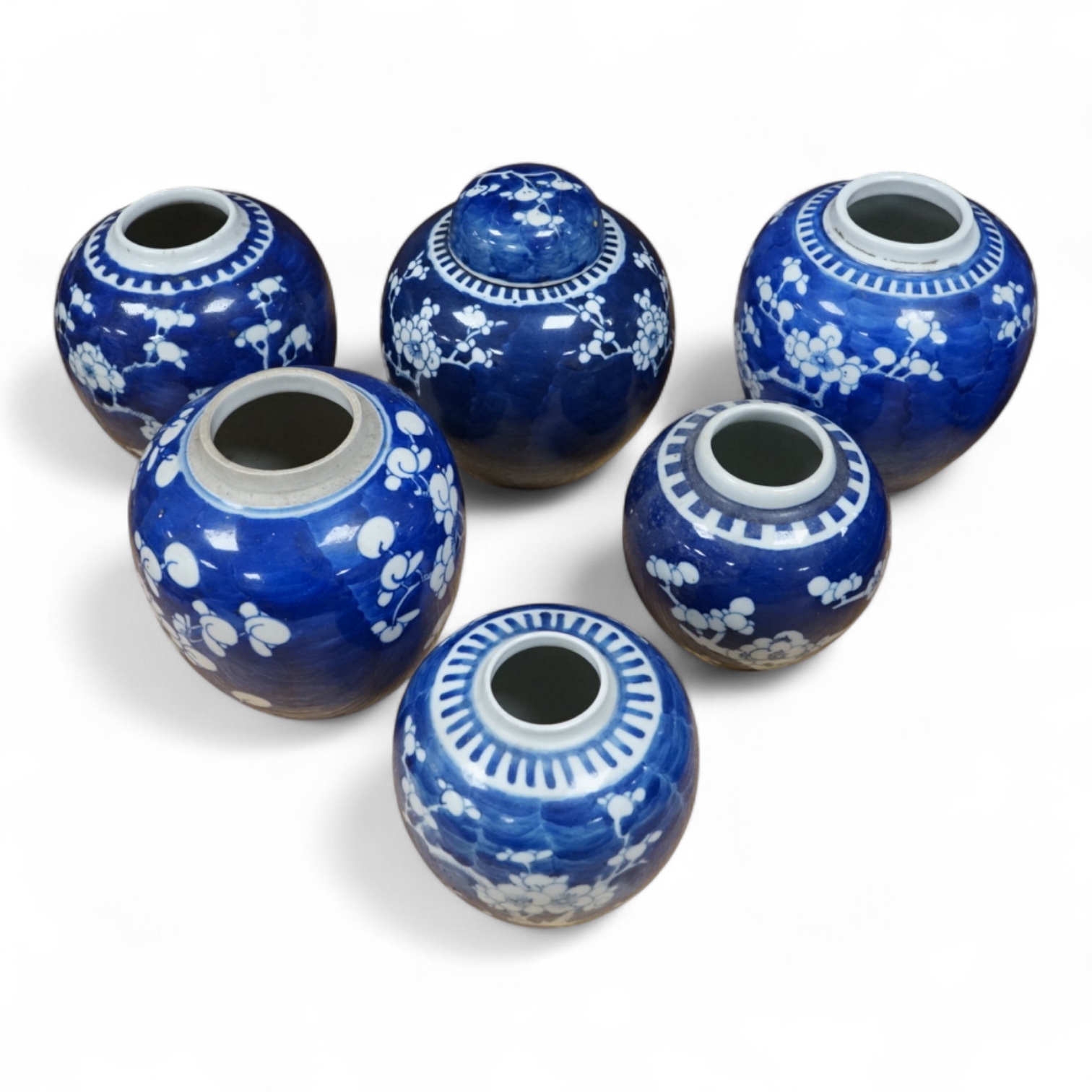 Six Chinese blue and white ginger jars, of varying height, one with a cover. Jar and cover 15cm high. Condition - fair